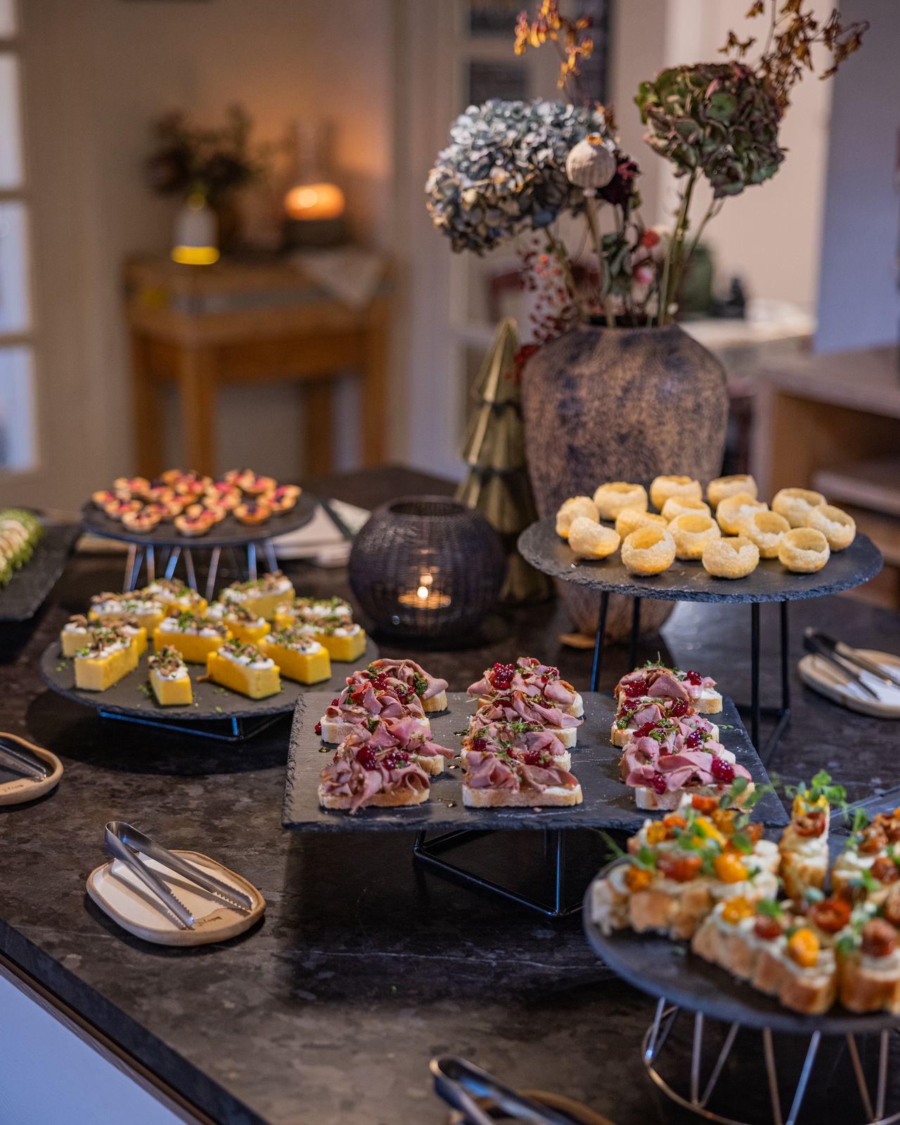 Weihnachtsbrunch im habs*gut: Platten mit Delikatessen und Gebäck, dazwischen Kerzen und ein kleiner Christbaum