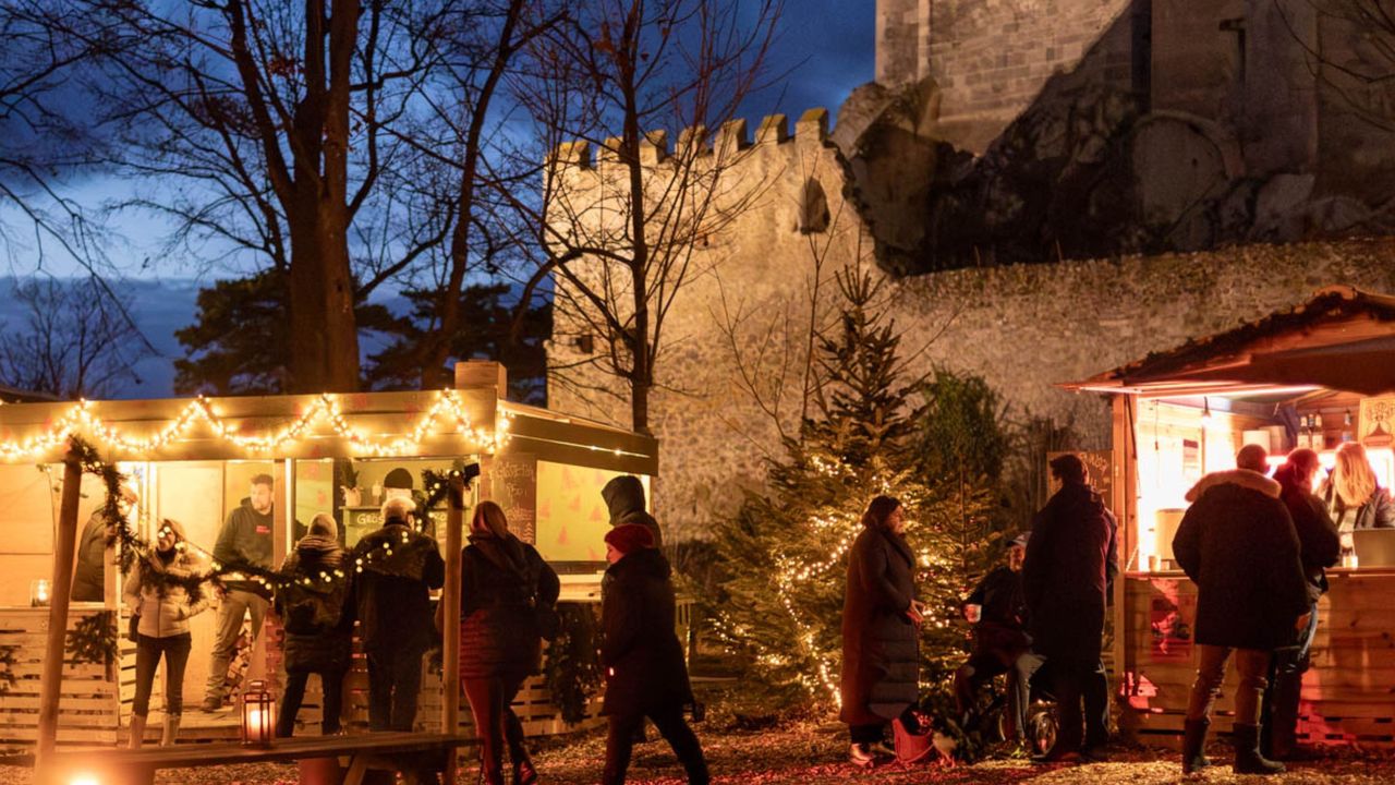 Weihnachtsmarkt an der Mauer der Burg Liechtenstein zur blauen Stunde