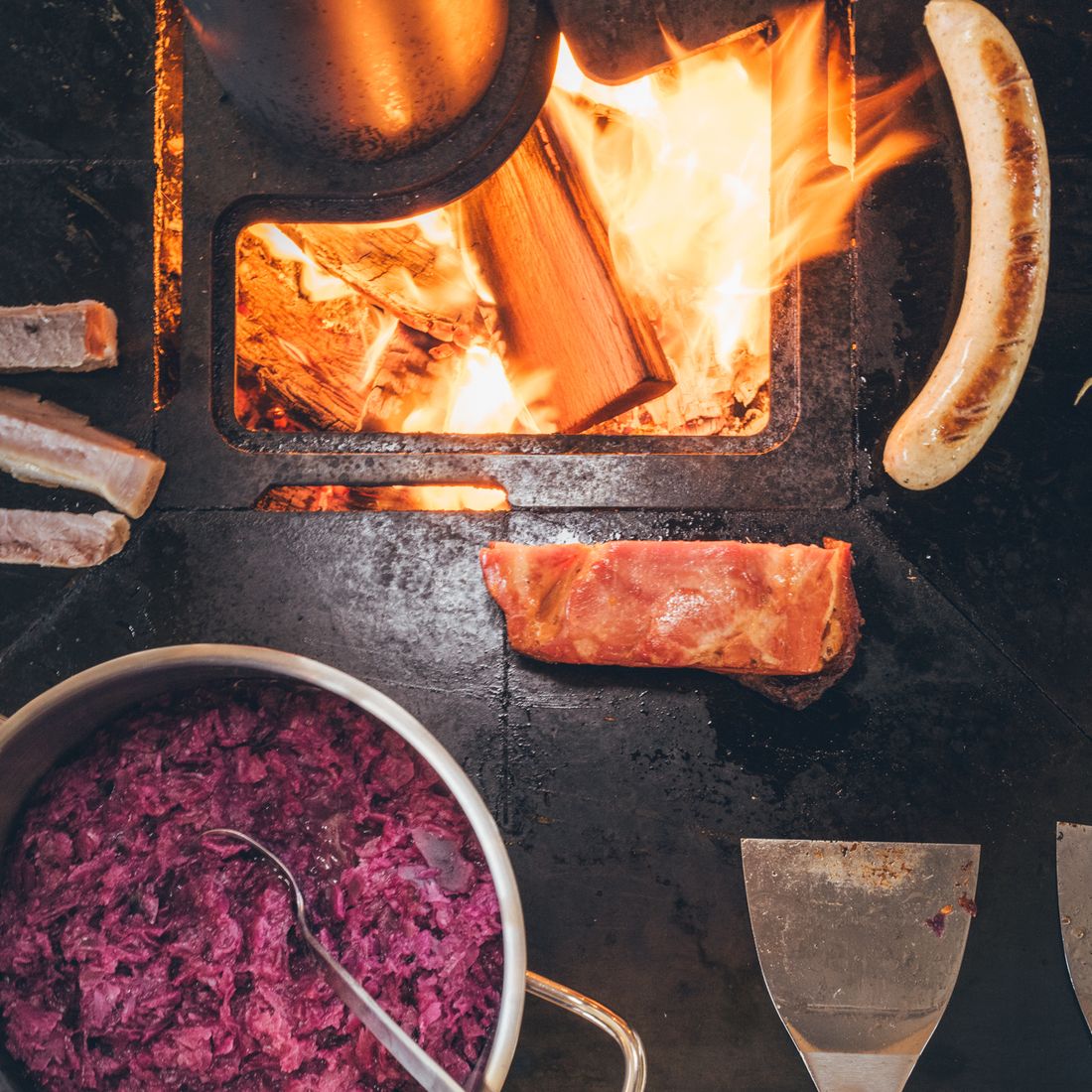 Winterliche Schmankerl über offenem Feuer: Grillwürstel, Speck und Blaukraut
