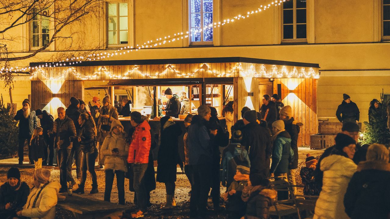 Weihnachtsfeier im habs*gut: beleuchtete Punschhütte, Lichterketten und Gäste auf dem privaten Weihnachtsmarkt bei Wien