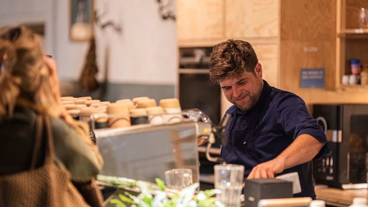 Vorschaubild: Barista an der Siebträgermaschine in der habs*gut Tagesbar, im Vordergrund ein wartender Gast